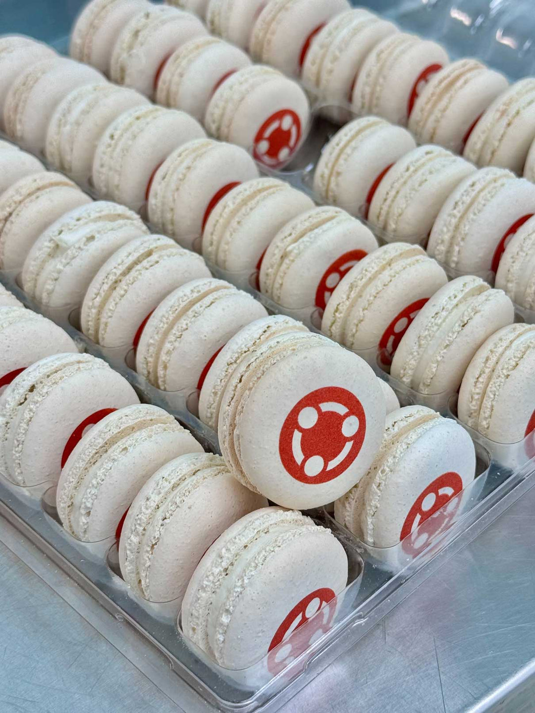 white macarons in a 50 pack with a logo printed on them