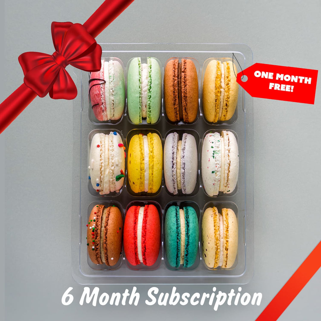 Box of colorful macarons with a red ribbon and promotional tag on a gray background