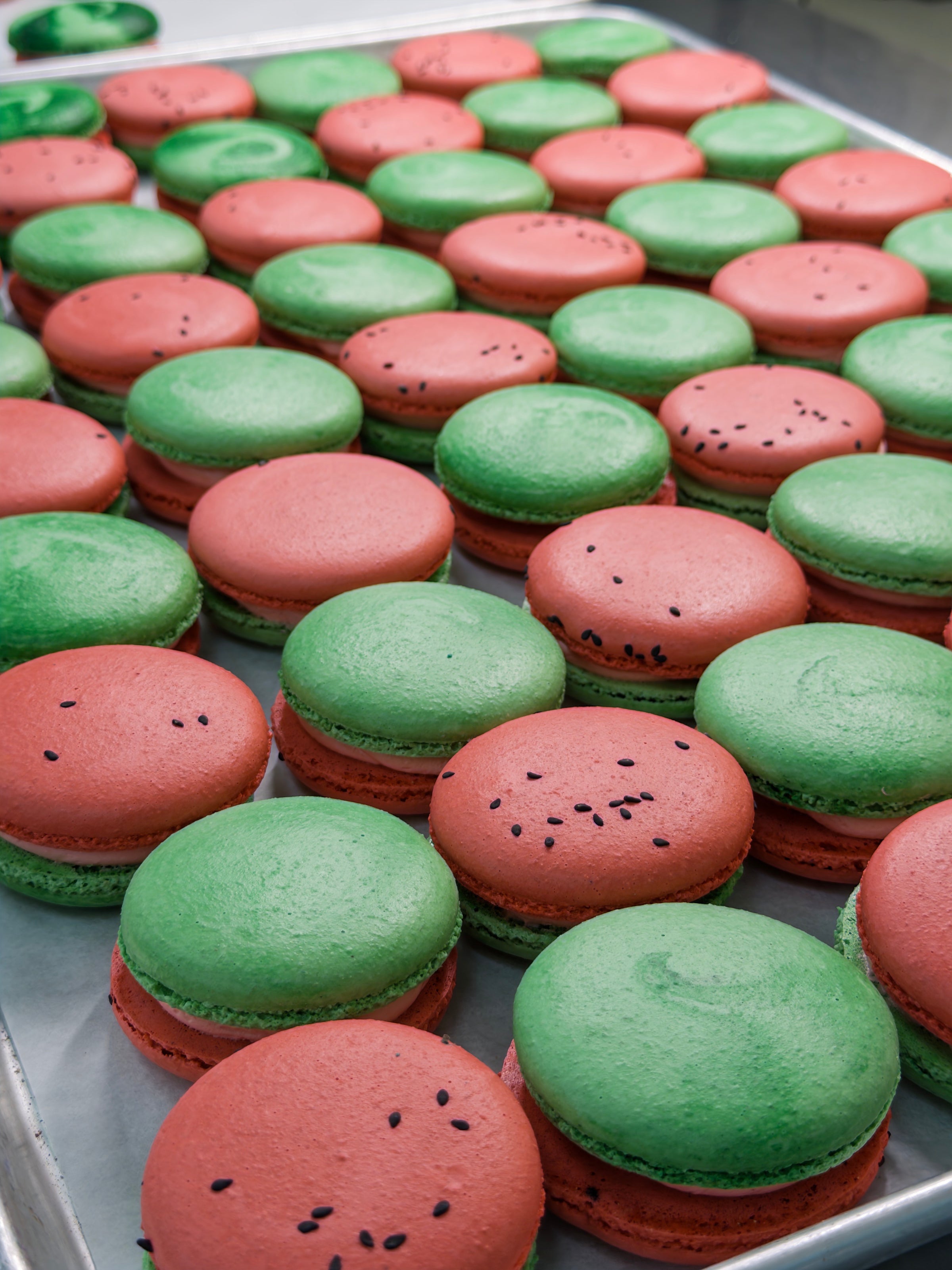 Macarons shaped like watermelons on a tray