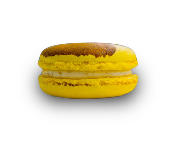 Yellow macaron with a brown top on a white background