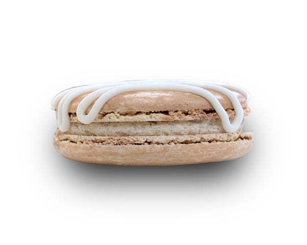 Brown macaron with white icing on a white background