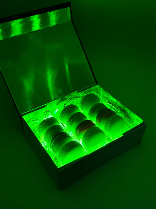 A box of macarons illuminated by green LED lighting when the box is opened.