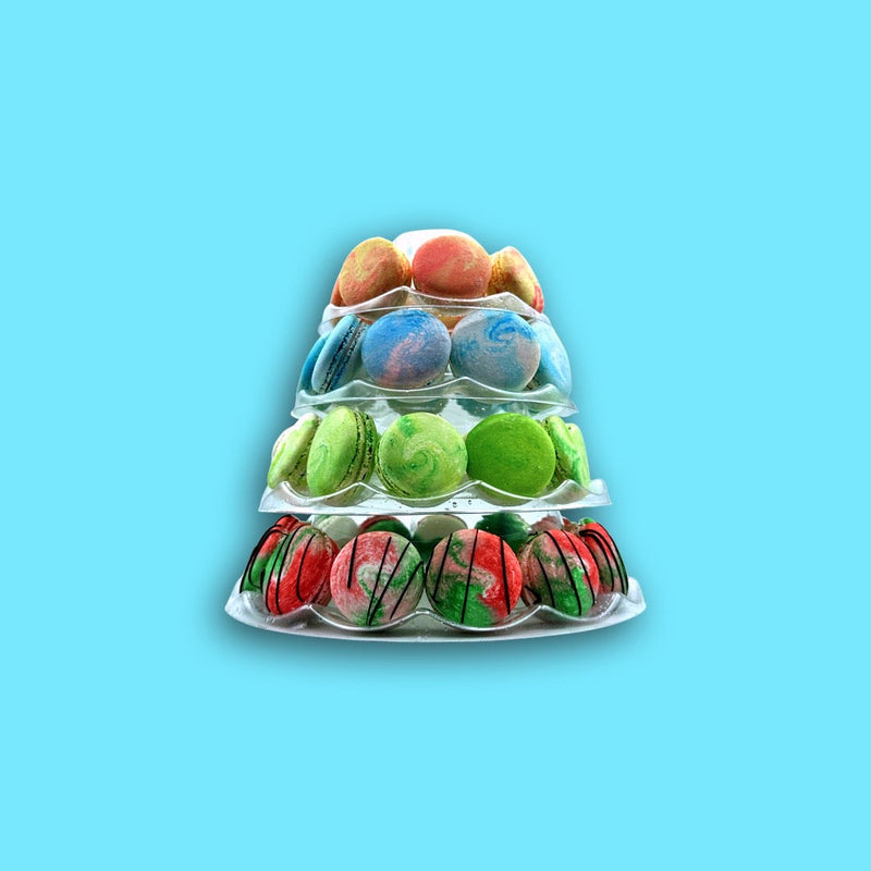 a four tier tower of french macarons on a blue background