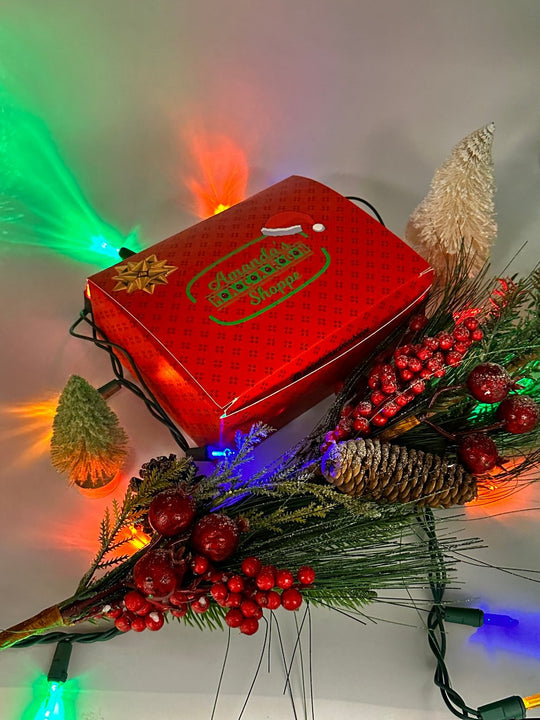 Closed gift box of French macarons with Christmas lights and decorations