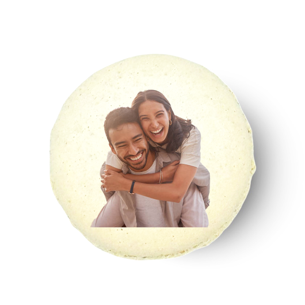 A personalized macaron with a printed image of two people embracing.