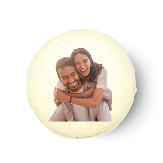 A personalized macaron with a printed image of two people embracing.